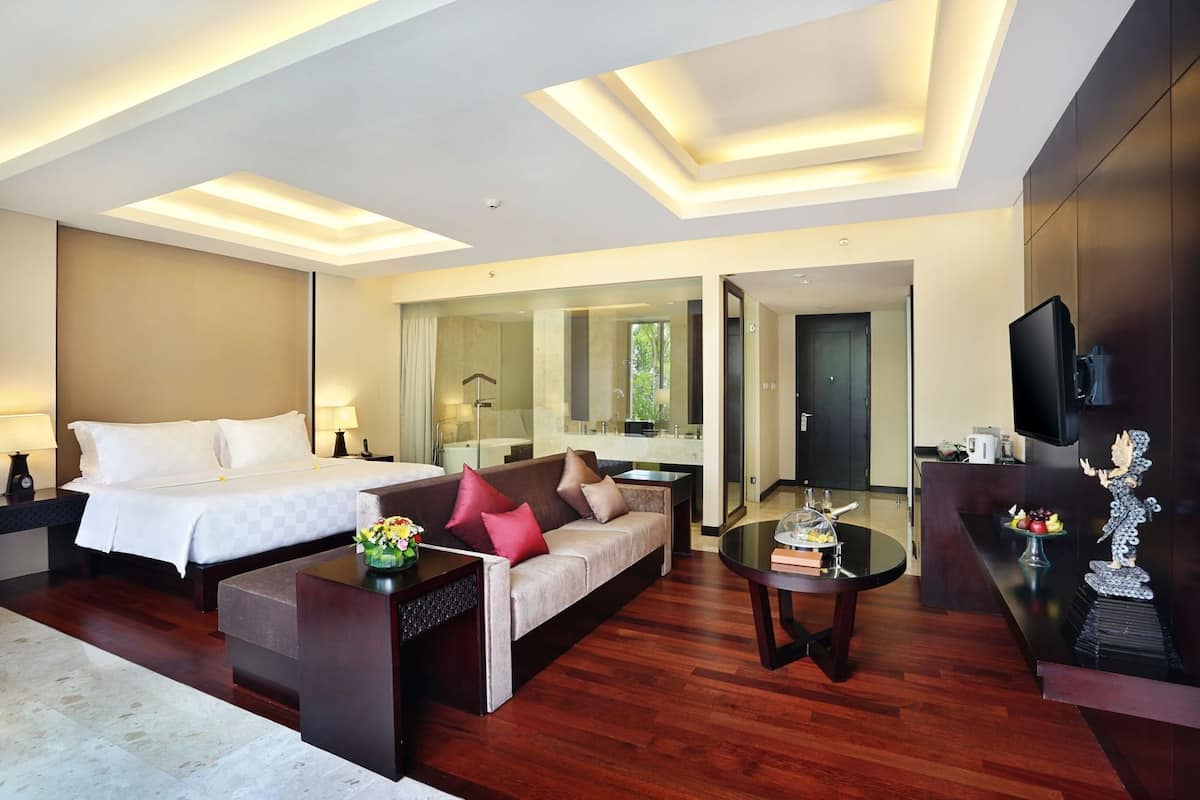 Une chambre d’hôtel moderne équipée d’un lit, d’un canapé, d’une table basse et d’un téléviseur.