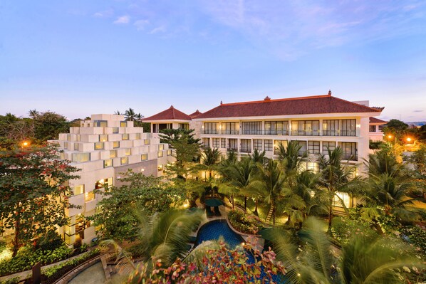 A resort with multiple buildings, a swimming pool, and lush greenery. - Bali Nusa Dua Hotel (Nusa Dua)