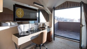 A modern hotel room with a desk, chair, and a large window offering a city view. - GK Regency Suites (Istanbul)