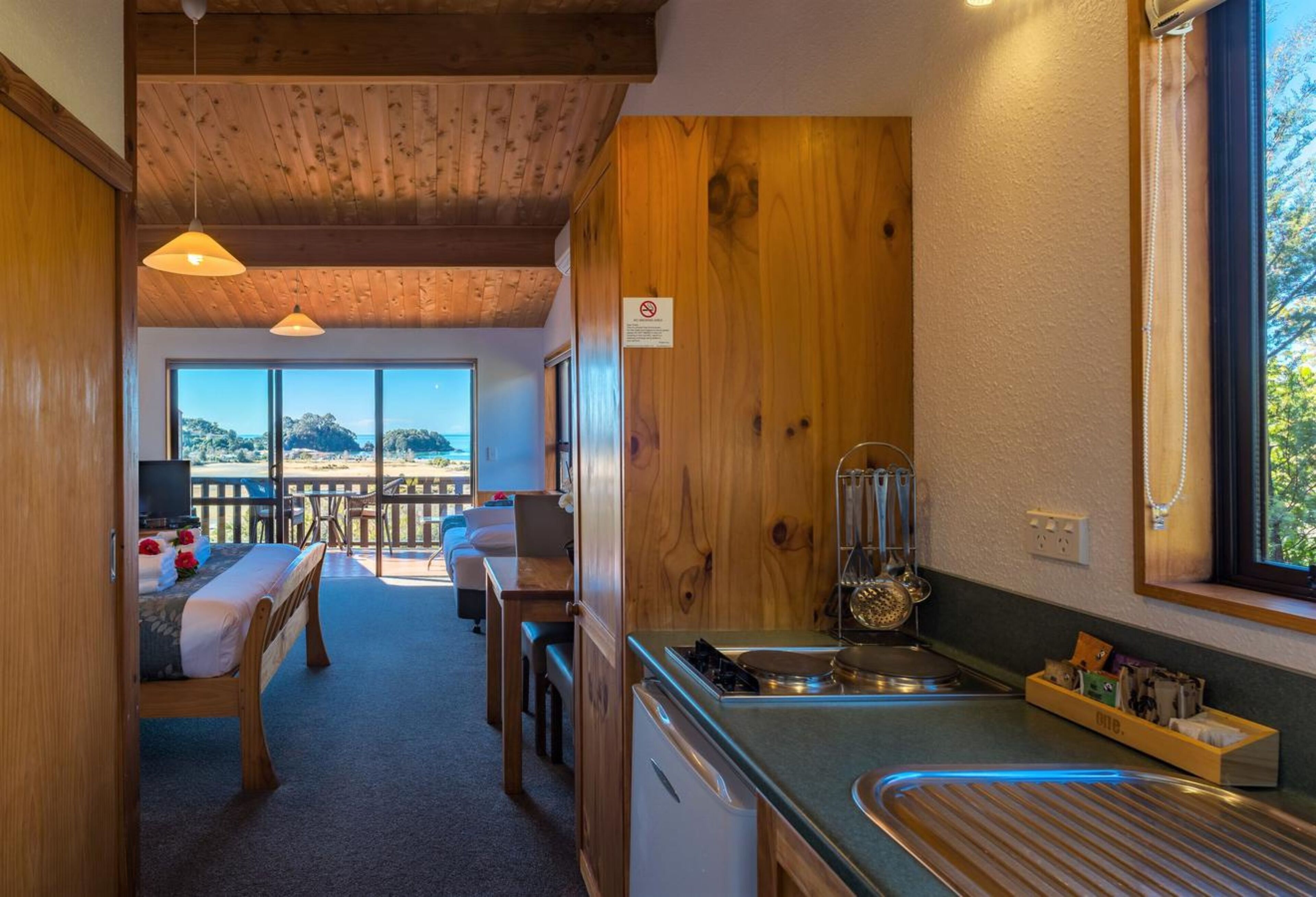 A cozy kitchen with wooden accents, a dining area with a view, and a balcony with a wooden railing.