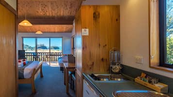 A cozy kitchen with wooden accents, a dining area with a view, and a balcony with a wooden railing.