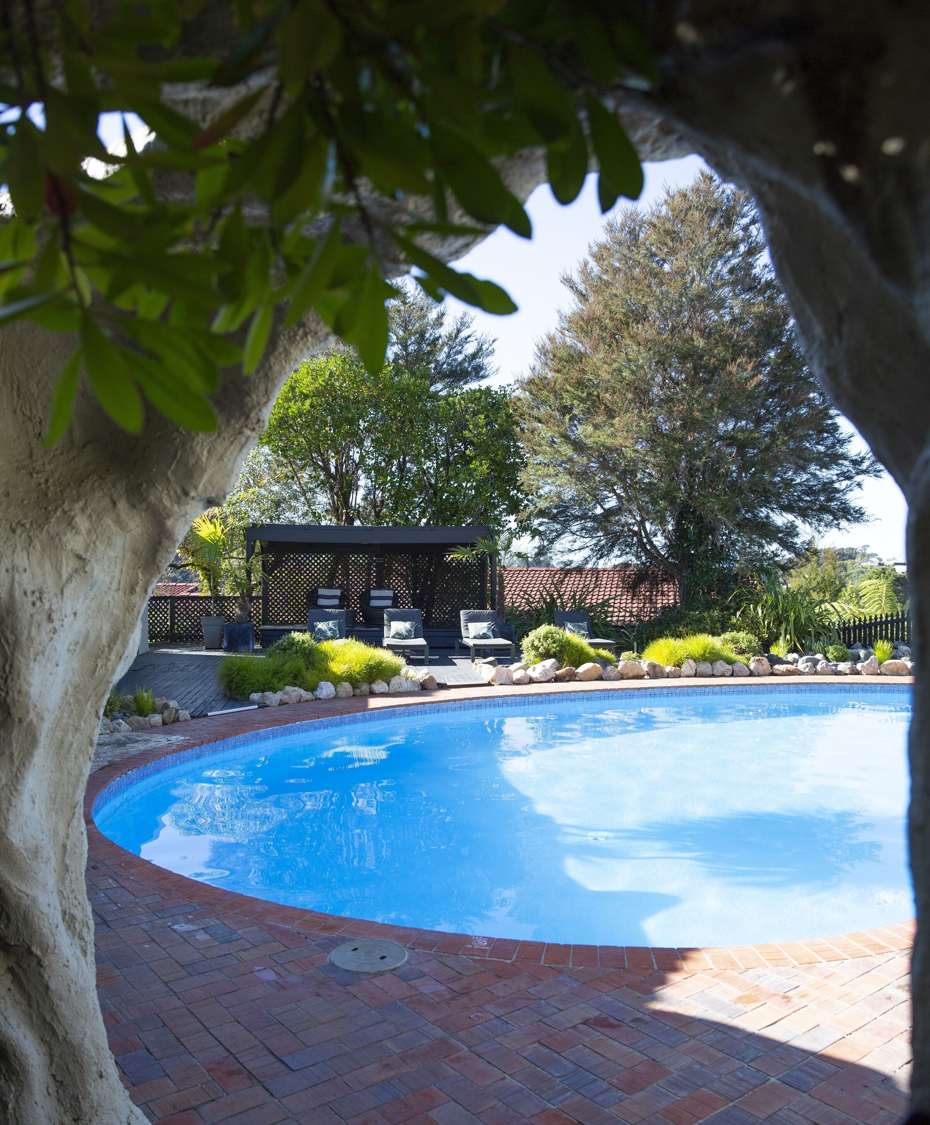 Una piscina techada, una piscina al aire libre, sombrillas