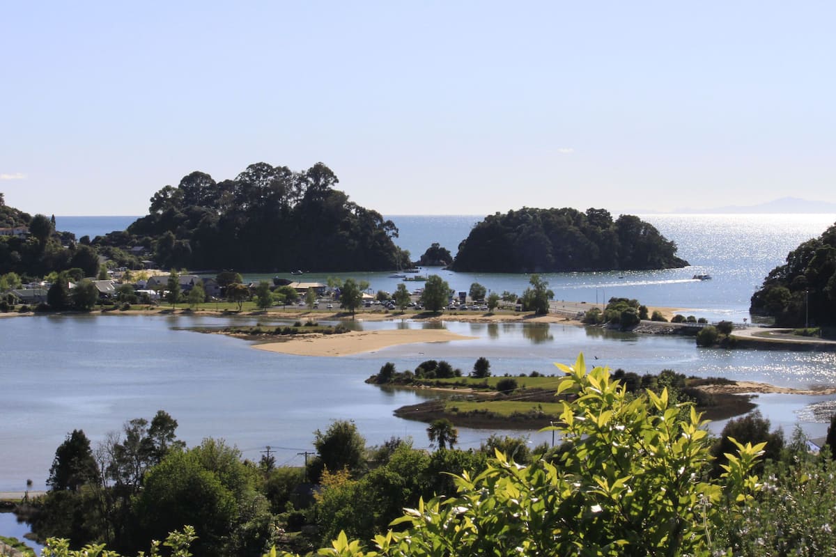 A coastal landscape with a lake, trees, and a small island.