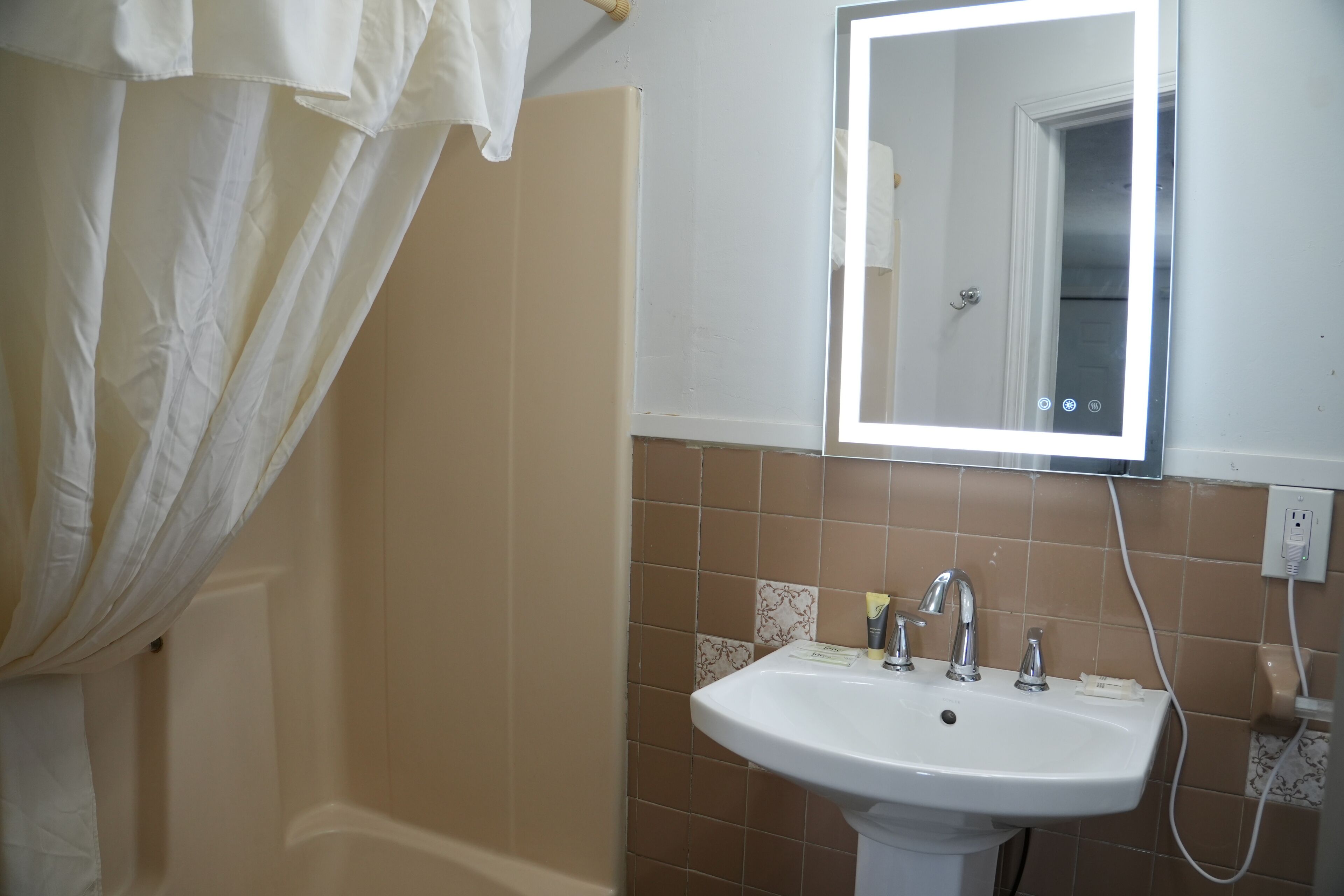A bathroom with a white sink, a mirror, and a shower curtain.