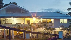 Un hotel con piscina, zona cubierta y tobogán.