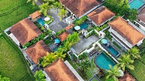 An aerial view of a resort with multiple buildings, swimming pools, and lush greenery. - The Sakara Ubud Villas (Tegallalang)