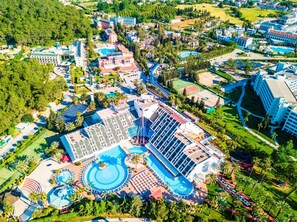 An aerial view of a resort with multiple buildings, a large swimming pool, and a water park. - Queen's Park Resort Goynuk - All Inclusive (Kemer)