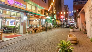 A cobblestone street lined with restaurants and hotels, including Viva Motel Deluxe and Erbil Hotel. - Viva Deluxe Hotel (Istanbul)