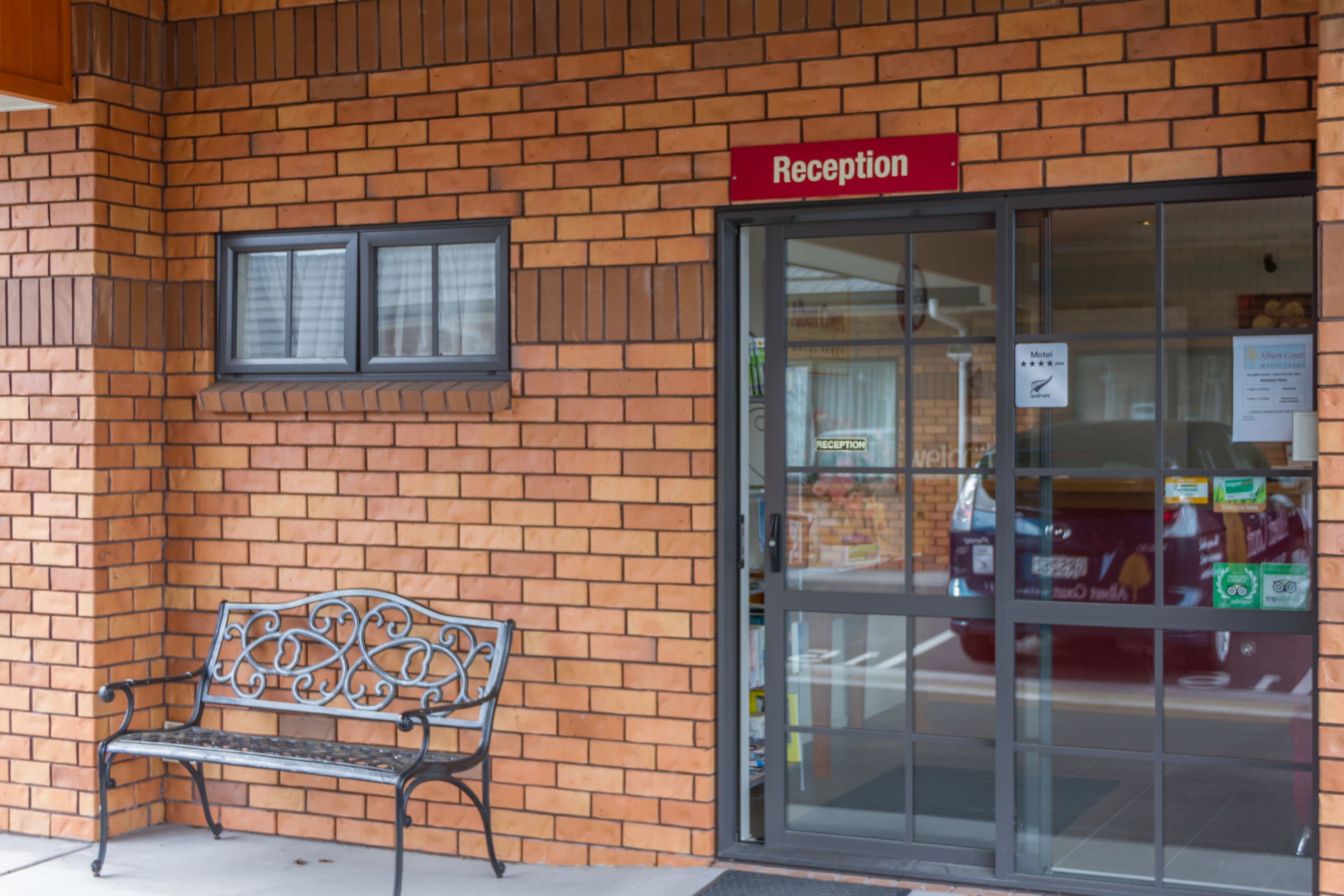 Uma área de recepção com um banco e uma porta de vidro.