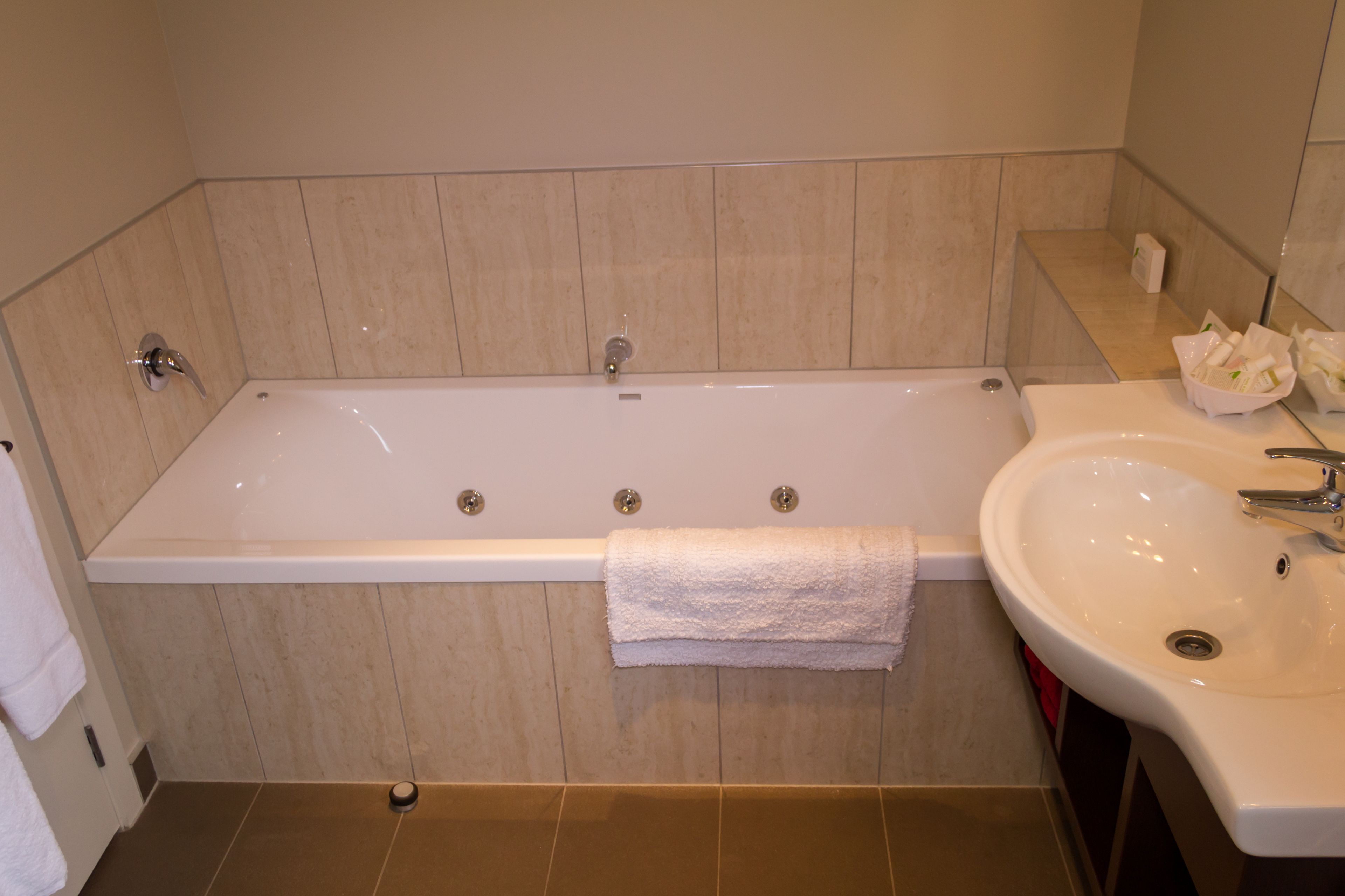 A bathroom with a bathtub, a sink, and a towel rack.