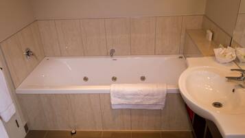 A bathroom with a bathtub, a sink, and a towel rack.