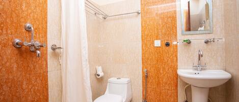 Une salle de bain comprenant des toilettes, une douche et un lavabo.