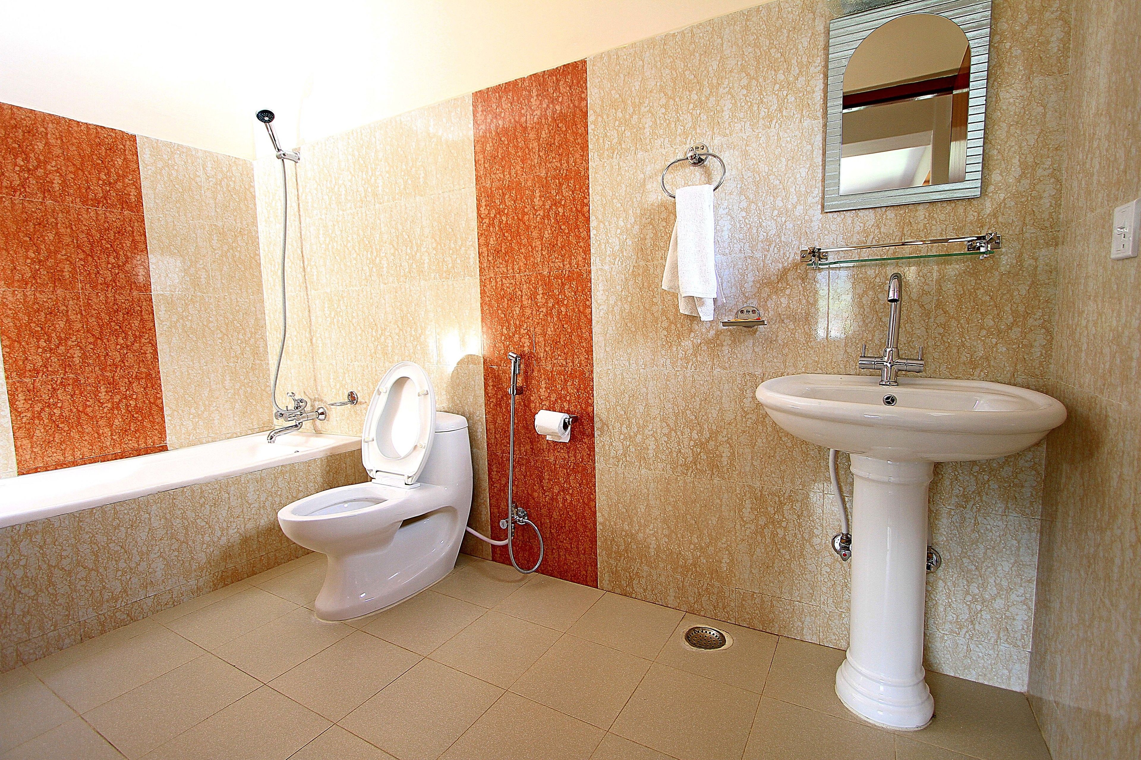 Un baño con inodoro, lavamanos y ducha.