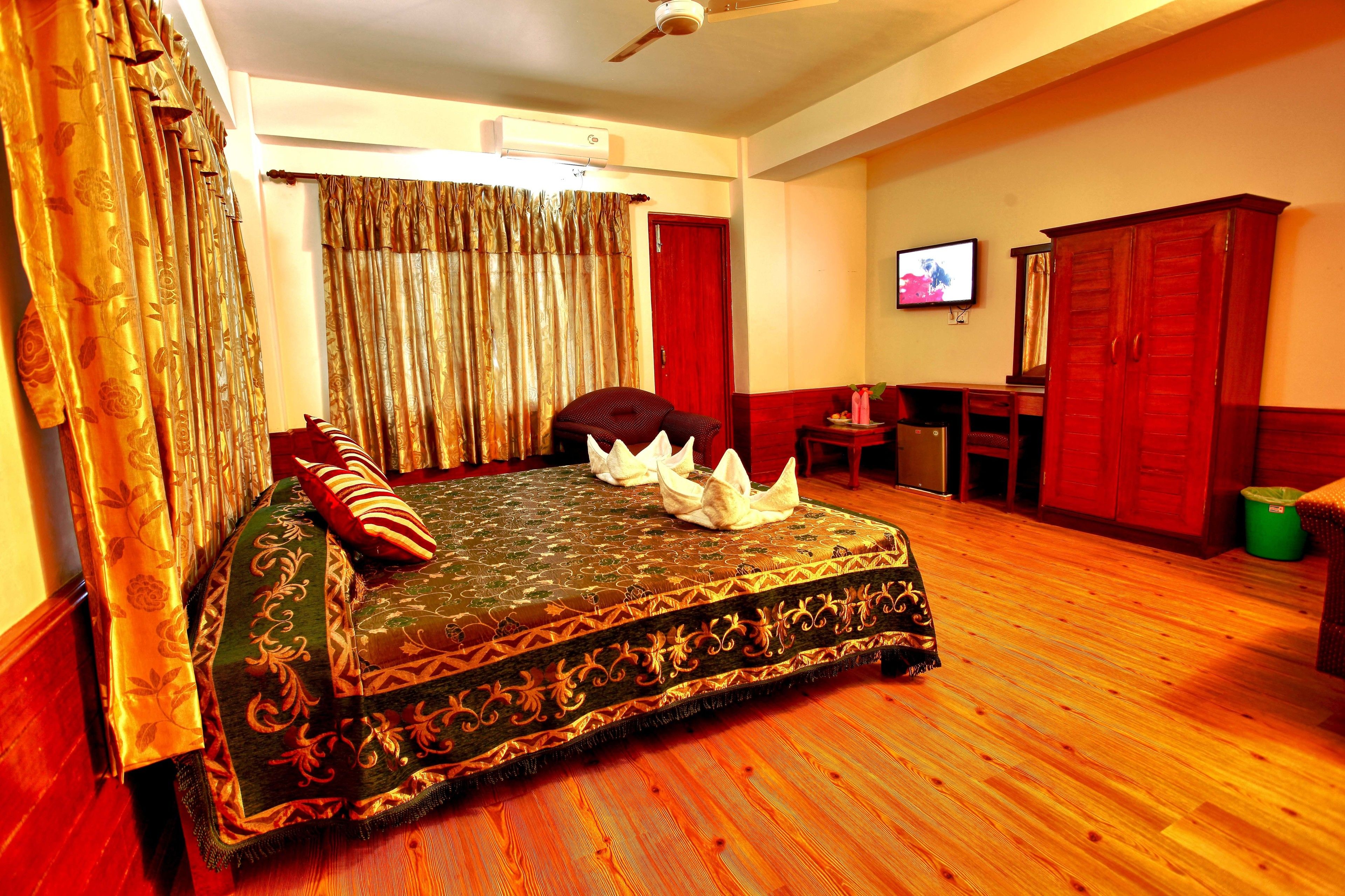 A room with a bed, a television, and a desk.
