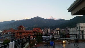 Vista de un paisaje montañoso con un edificio en primer plano.