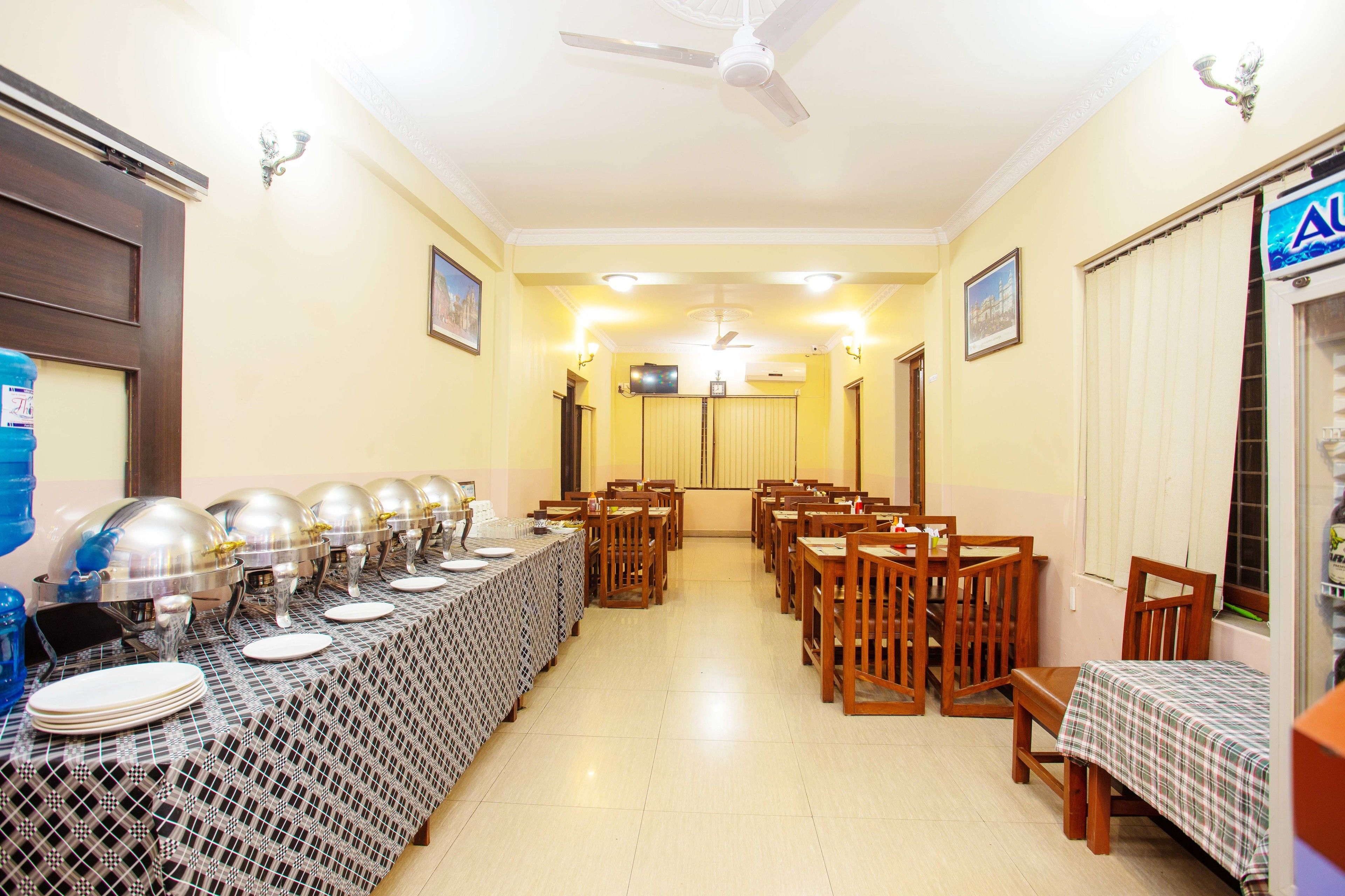 A dining hall with long tables, chairs, and buffet service.