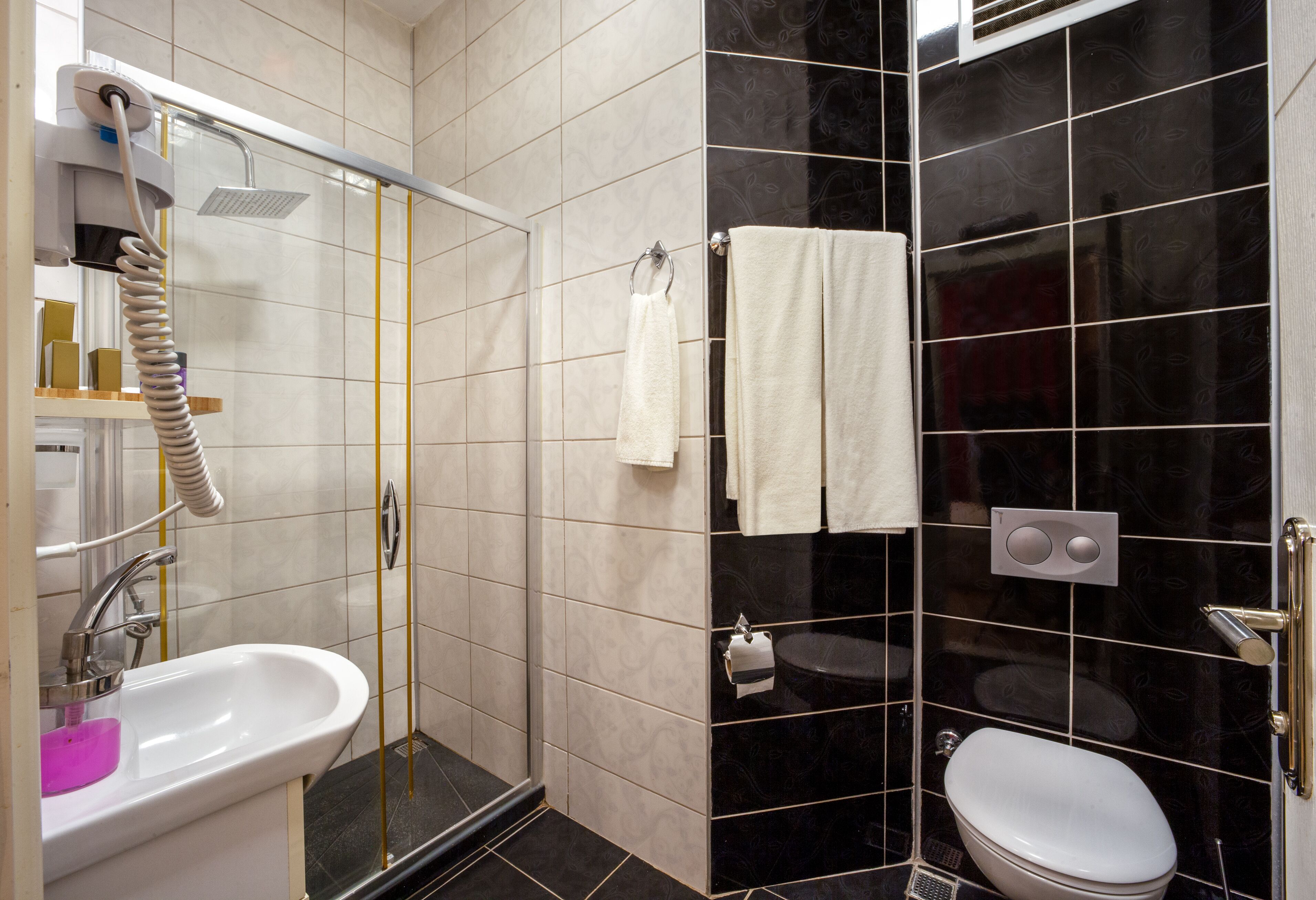 deluxe double room with brick wall | bathroom | shower, free toiletries, hair dryer, slippers