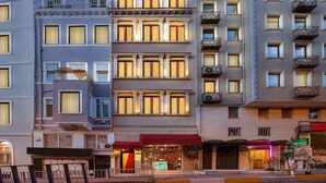 A multi-story hotel with balconies, large windows, and a storefront with a red awning. - Nine Istanbul Hotel (Istanbul)