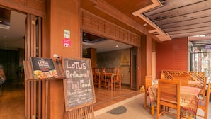 A restaurant with wooden furniture and a chalkboard menu. - Lotus Hotel Patong (Patong)