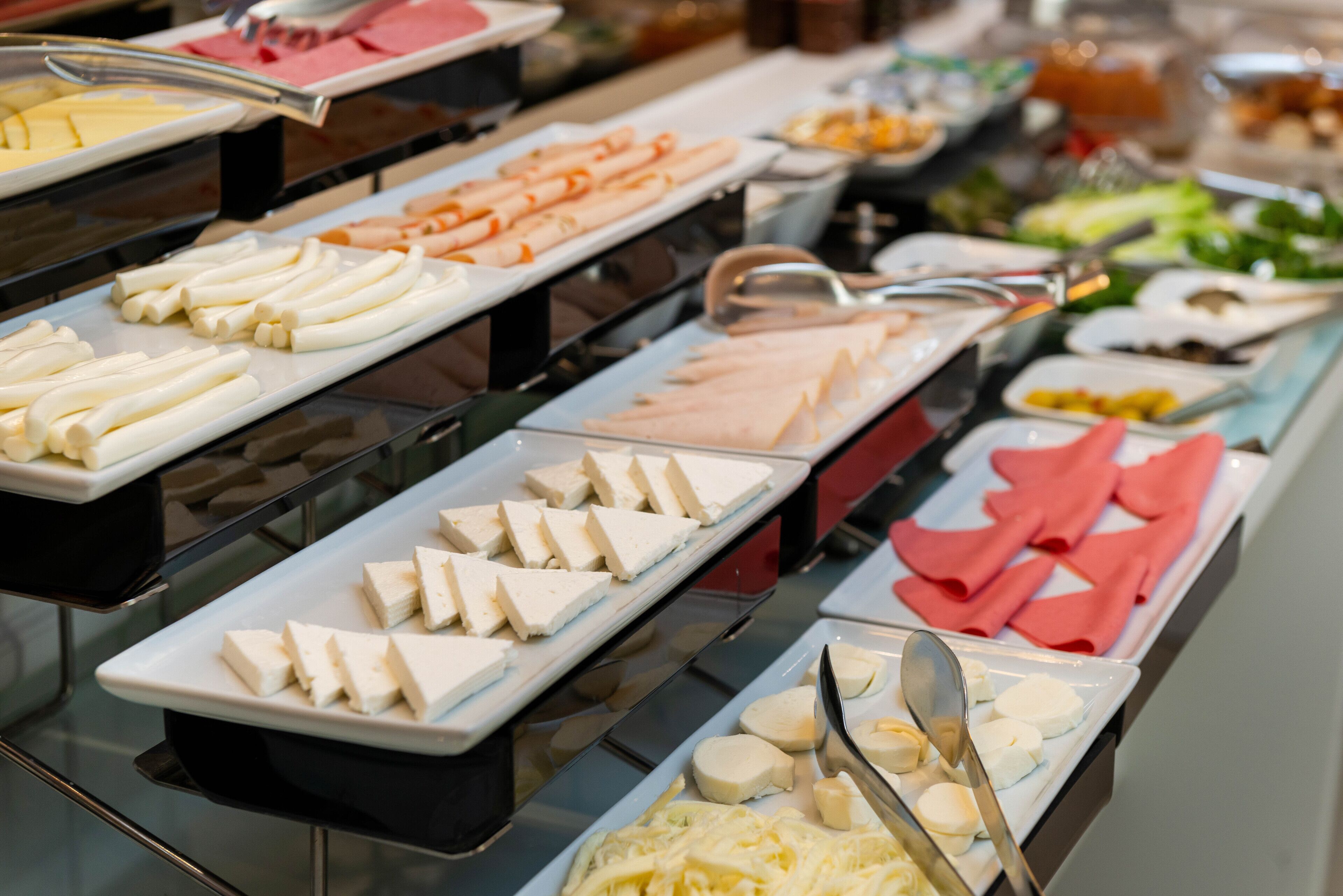 Un bufé con diversos alimentos, incluyendo queso, frutas y verduras.