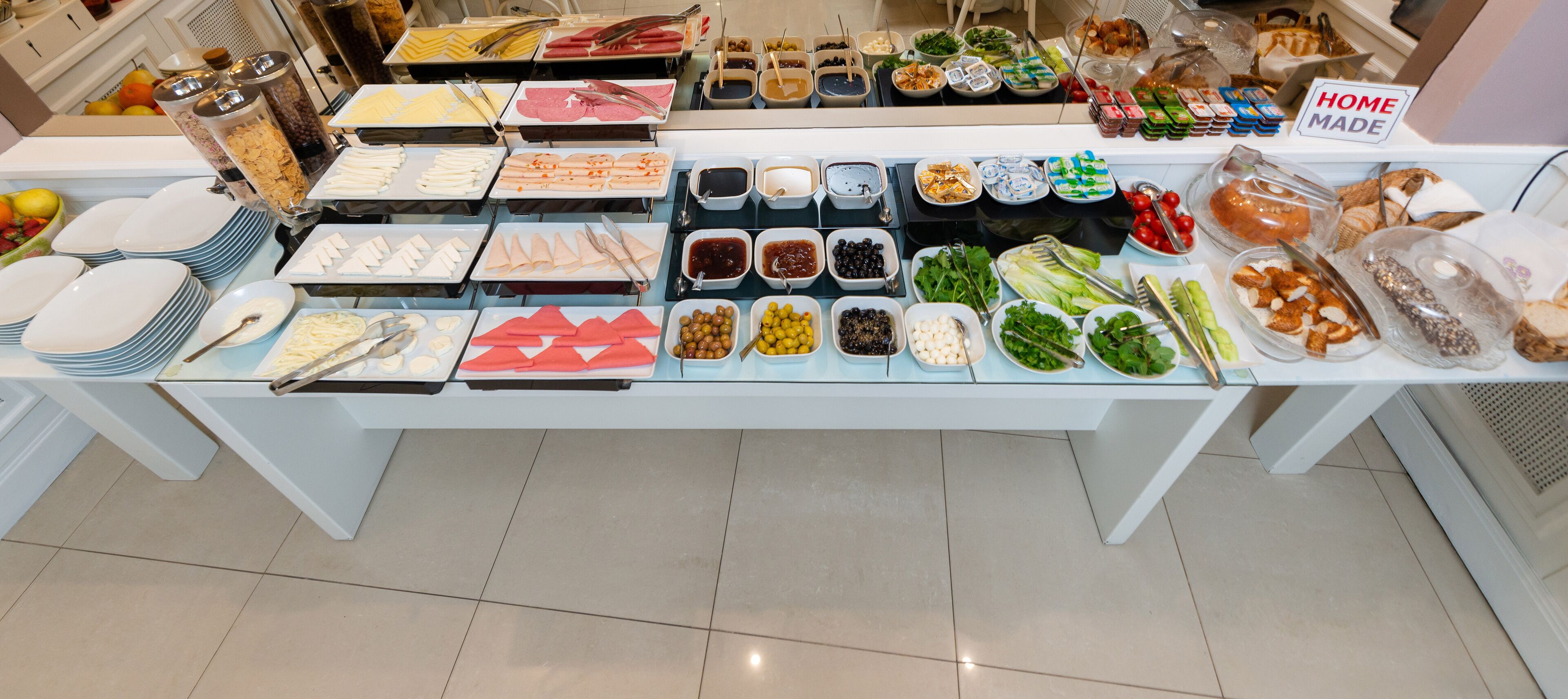 Una mesa de buffet con diversos alimentos y utensilios.