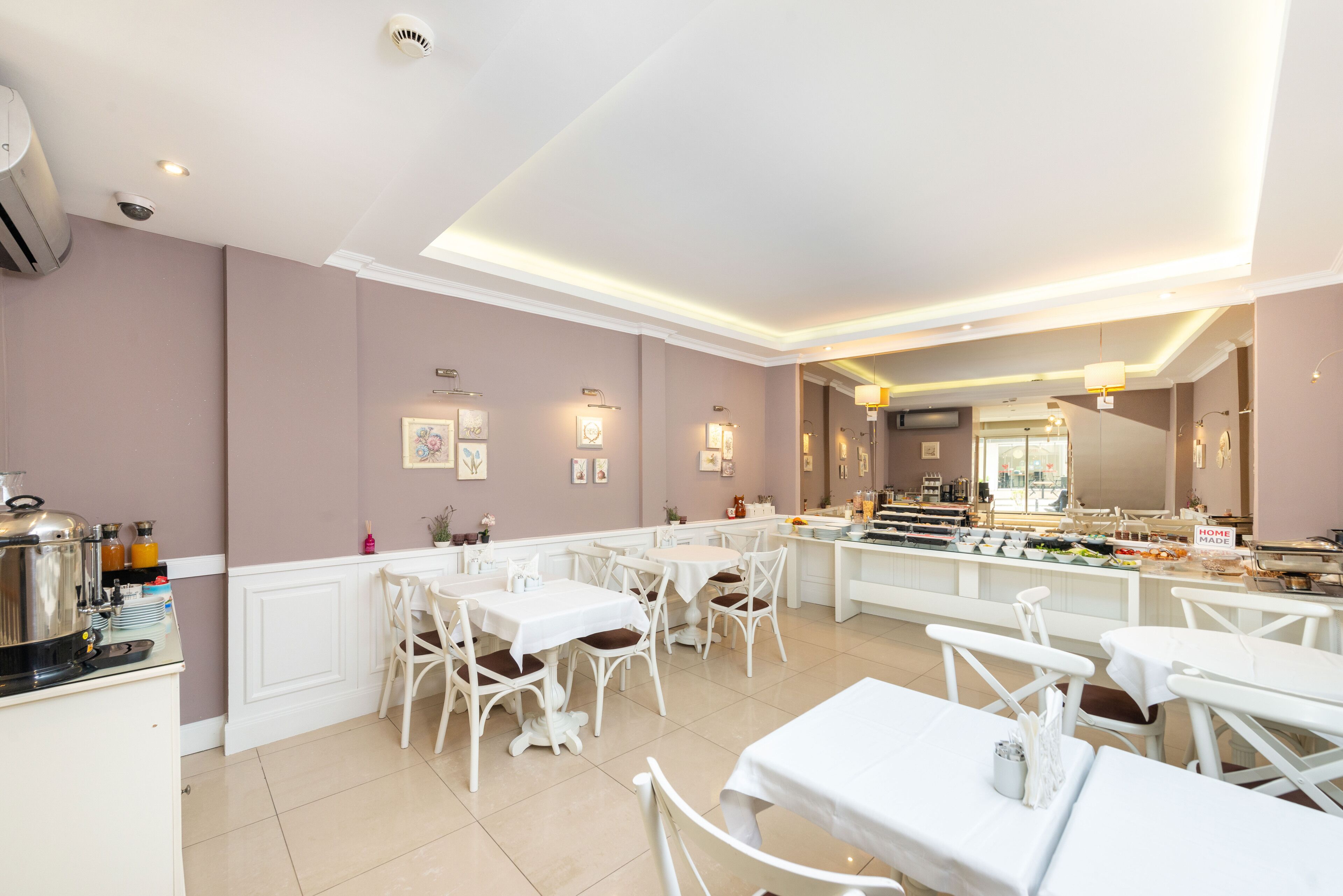 Uma sala de jantar moderna com mobiliário branco e uma ilha central com apresentações de comida.