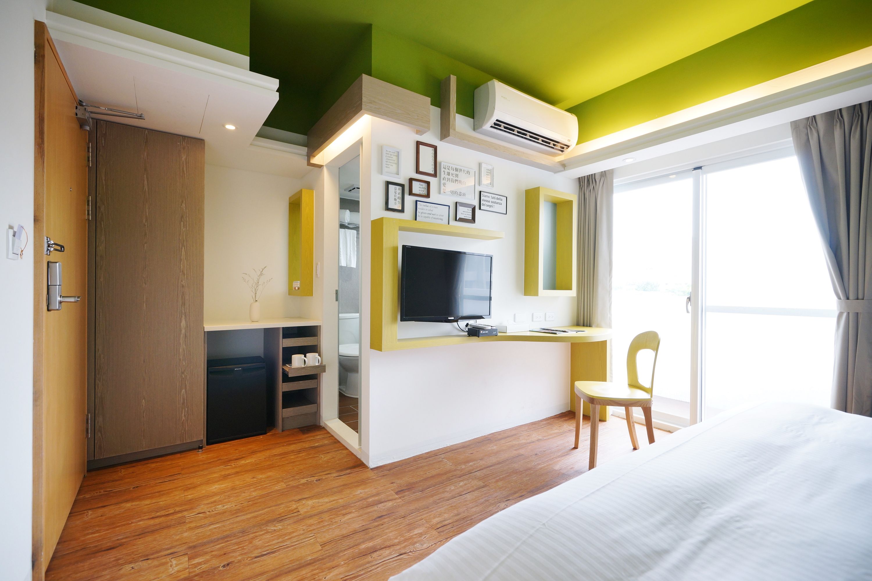 Una habitación de hotel con una cama, un escritorio, una silla, un televisor y un armario.