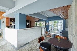 Un comedor moderno con una isla central, asientos alrededor y ventanas amplias que brindan luz natural.
