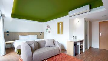 Una habitación de hotel moderna con cama, sofá y kitchenette.
