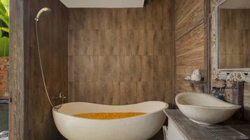 A bathroom with a freestanding bathtub, a sink, and a shower.