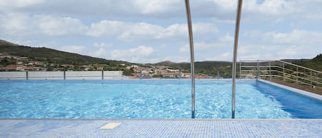 Una piscina cubierta, una piscina al aire libre de temporada, tumbonas