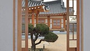 Un edificio tradizionale giapponese con struttura in legno e un bonsai curato in primo piano.