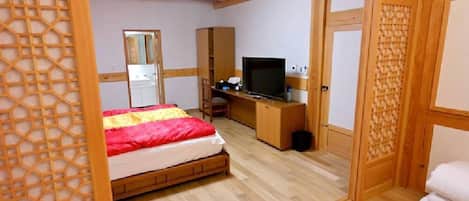A room with a bed, a TV, a desk, and a wardrobe.