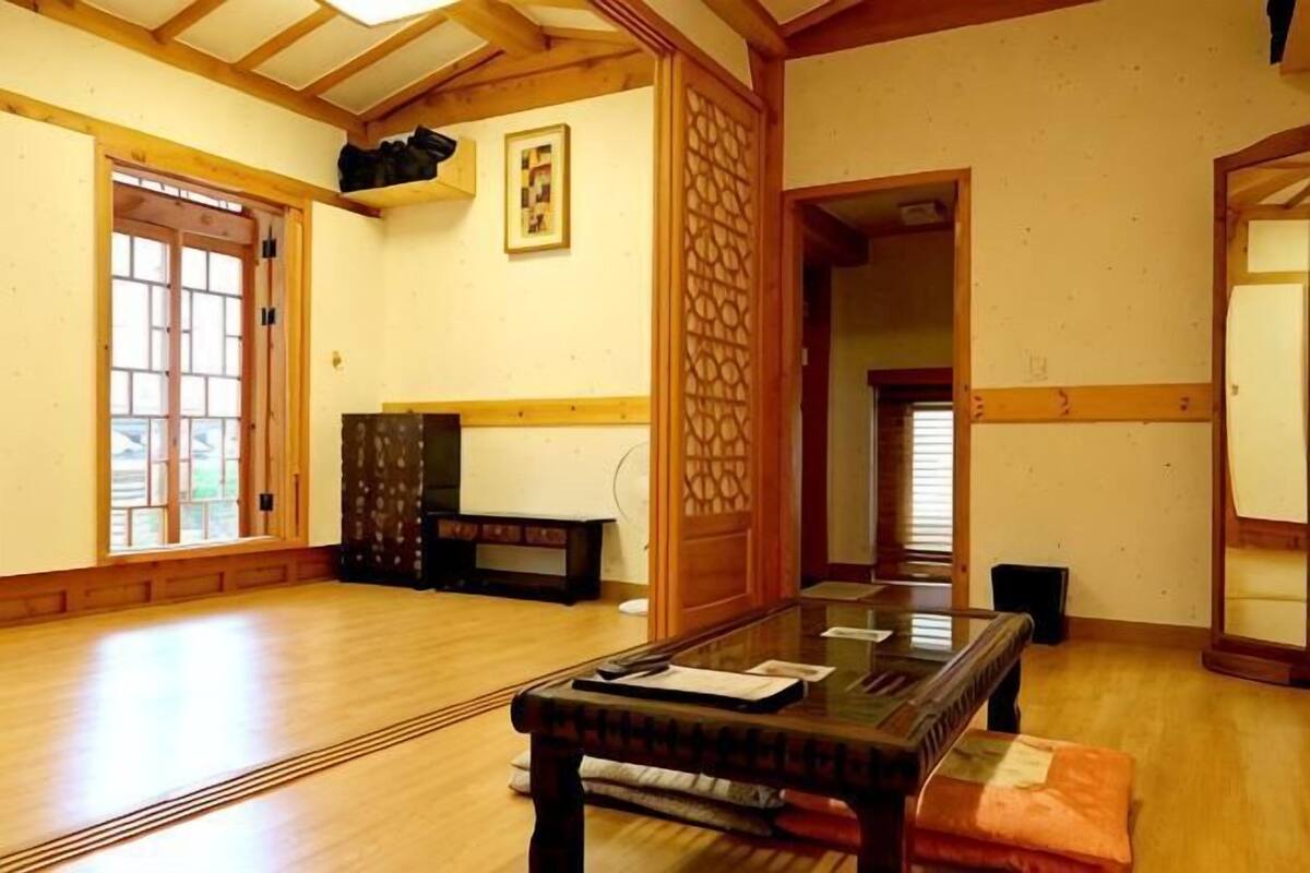 Una habitación japonesa tradicional con suelo de tatami, una mesa baja y puertas correderas.