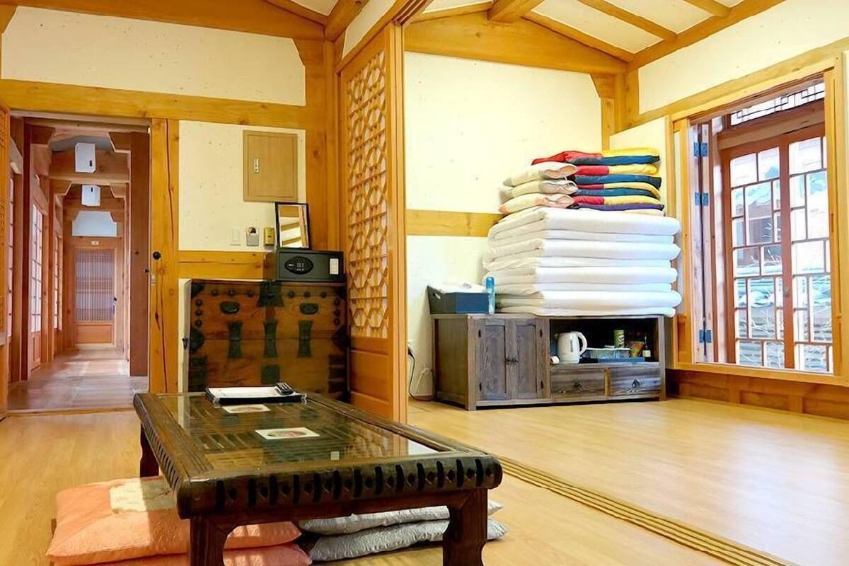 Um quarto tradicional japonês com tatames, uma mesa de madeira baixa e um futon.