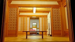 Una tradizionale stanza giapponese con pavimento in tatami, un tavolino in legno e porte scorrevoli con motivi a griglia.