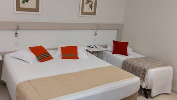 Una habitación de hotel con dos camas, una mesita y un equipo de aire acondicionado.