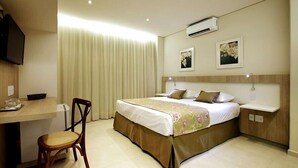 Ein Hotelzimmer mit Bett, Schreibtisch und Stuhl.