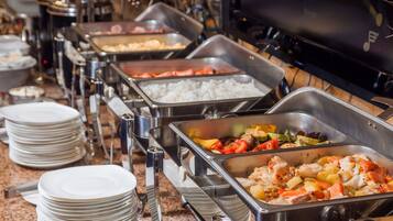 Ein Buffet mit verschiedenen Speisen, darunter Reis, Gemüse und Fleisch.