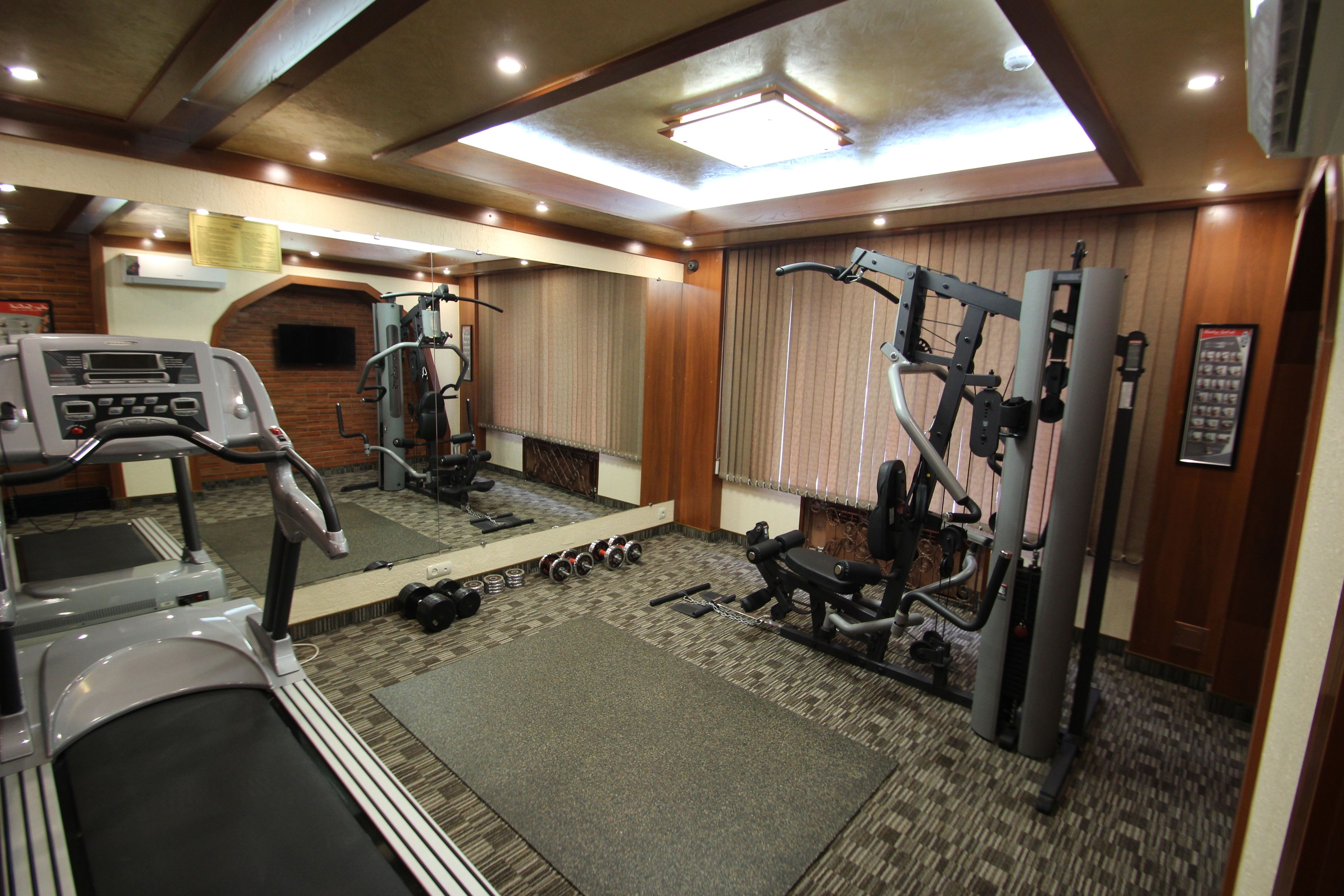 A gym with treadmills, dumbbells, and exercise machines.