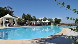 A swimming pool with a white deck, surrounded by palm trees and a clear blue sky. - Grand Hotel Stella Maris Italia (Palmi)