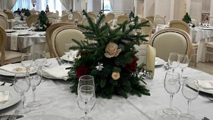 A formal dining room with tables set for a meal, featuring Christmas decorations and a chandelier. - Grand Hotel Stella Maris Italia (Palmi)