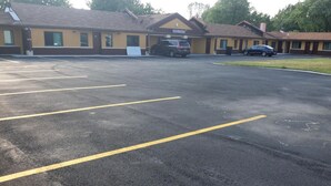 A motel with a large parking lot and a building with a sign that reads "Motel Office". - Royal Inn (Tonawanda)