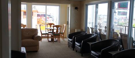 A hotel lobby with a seating area, a small table, and a view of the outside.