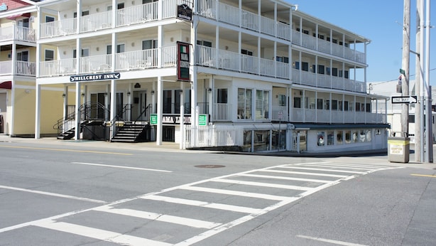 A multi-story hotel with balconies, a visible entrance, and a street view.