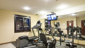 A gym with treadmills, a stationary bike, and weight machines. - Foxwood Inn & Suites (Drayton Valley)
