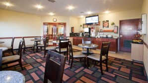 A hotel lobby with multiple seating areas, a reception desk, and a television screen. - Foxwood Inn & Suites (Drayton Valley)