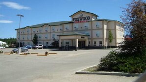 A Foxwood Inn & Suites building with a central entrance, multiple windows, and a parking lot. - Foxwood Inn & Suites (Drayton Valley)