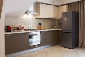 A modern kitchen with stainless steel appliances, a gas stove, and a built-in oven. - Sun City Arcadia Apartments (Odesa)