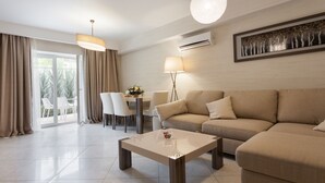 Un salon moderne avec un canapé beige, une table basse en verre et un coin repas comprenant des chaises et une table.
